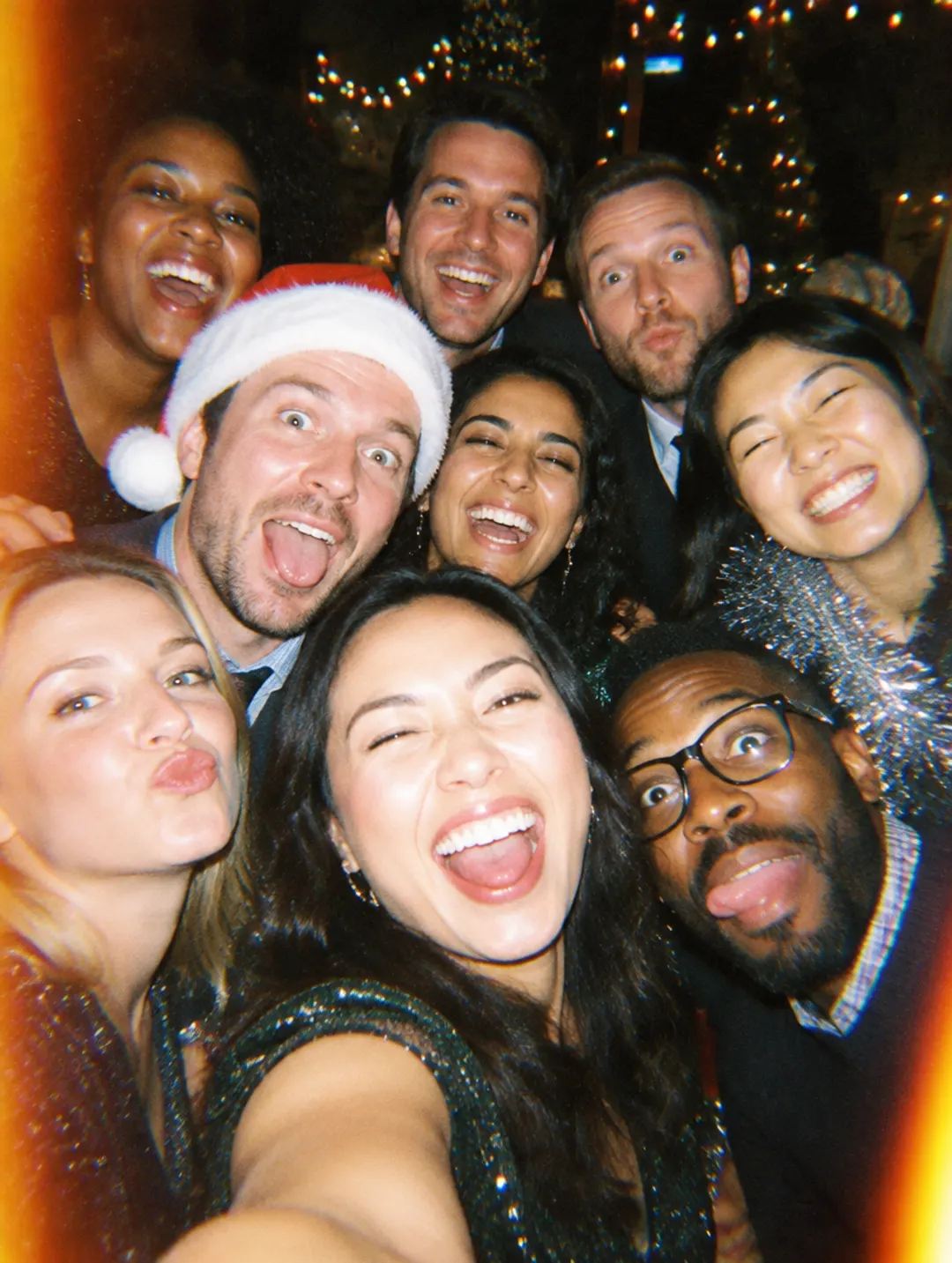 Coworkers taking a group selfie at a holiday party