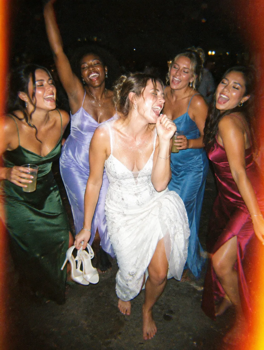 Bridesmaids dancing barefoot with the bride